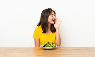 Caucasian girl with salad shouting with mouth wide open