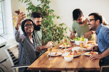 Enjoying dinner with friends. Group of cheerful young people enjoying dinner.