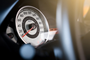 Speedometer on front car console with light flare.