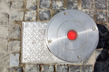 electrician hydro bollard gray metal with red lamp top view on stone tiles.