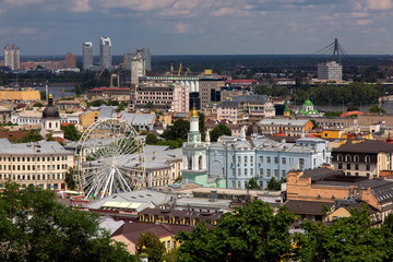 Ferris wheel in the historic center of a European city , top view on the roofs of houses.