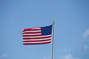 Fototapeta premium Flag of USA waving against blue sky