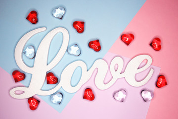 Word Love, on a pastel background with figures of hearts. Holiday concept. February 14, Valentine's Day, mother's day. 