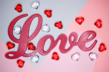 Word Love, on a pastel background with figures of hearts. Holiday concept. February 14, Valentine's Day, mother's day. 