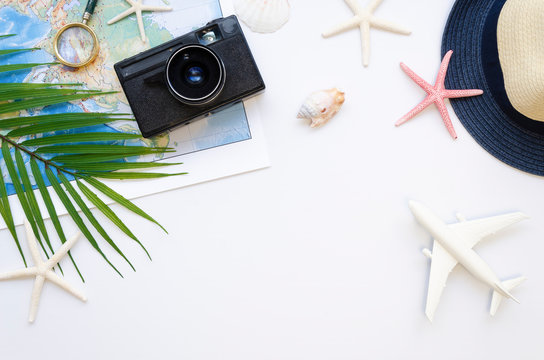 Table top view Travel bloggers accessories, Summer vacation items on a white background. Airplane, map, a camera frame with copy space
