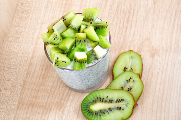healthy breakfast of chia yogurt and kiwi seeds on a wooden background. copy space
