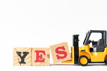 Toy forklift hold wood letter block s to complete word yes on white background