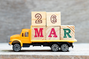 Truck hold letter block in word 26mar on wood background (Concept for date 26 month March)
