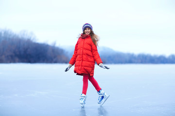 Fototapeta na wymiar Adorable little girl skating on ice rink on cold winter day