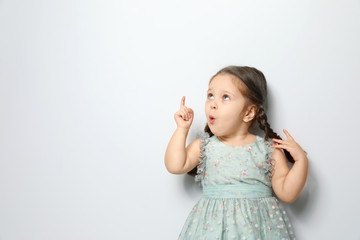 Cute little girl on light grey background. Space for text