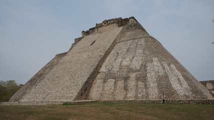 Traveler and the Mesoamerican Pyramid of the Magician in the ancient Pre-Columbian mayan city of Uxmal, Mexico. in Uxmal.