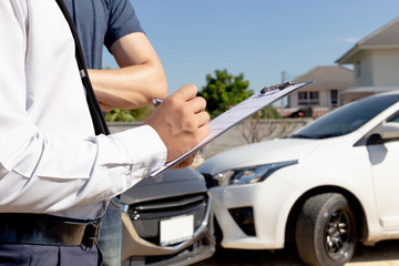 Insurance agents inspect for damage to cars that collide on the road to claim compensation from driving accidents, Insurance concept.