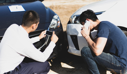 Insurance agents inspect for damage to cars that collide on the road to claim compensation from driving accidents, Insurance concept.