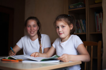  girls at   desk with notebooks and books
