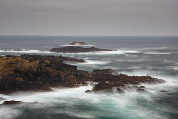 Fototapeta na wymiar Pescadores en las rocas de la costa de Valdoviño