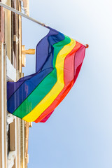 Rainbow flag during Amsterdam pride on background of blue sky