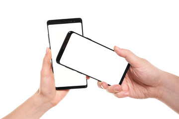 Two hands holding smartphones blank screen with modern frameless design while wireless transferring...