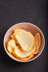 orange peel in small bowl on ceramic background
