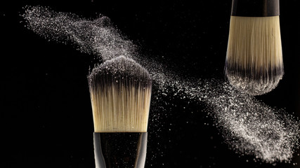 Flat blush brush on black background scatters blush around