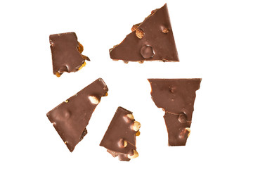 Scattered pieces of rectangular chocolate bar with peanut and raisin isolated on white background