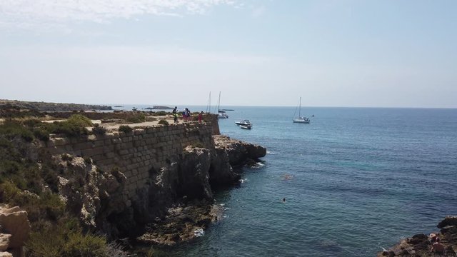 People jumping off cliffs on the island of tabarca.