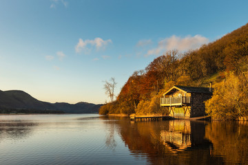 Obraz premium Epic vibrant sunrise Autumn Fall landscape image of Ullswater in Lake District with golden sunlight