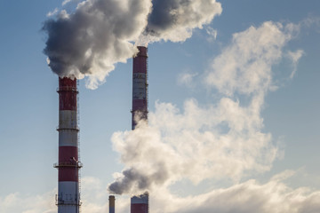 Smoke coming from three factory chimneys. Global warming. Air pollution.