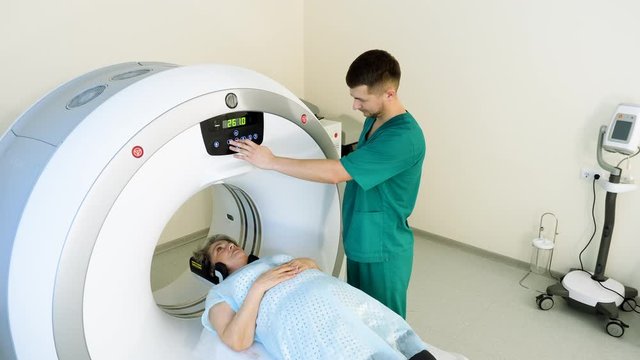 Procedure of computer tomography or magnetic resonance imaging. Elderly female patient on medical examination. CT or MRI scan. 4K