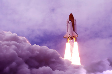 The launch of the space shuttle in an unusual, purple color. Elements of this image were furnished by NASA