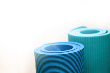Blaue Yogamatte Rolle als workout equipment. Geringe Schärfentiefe für Yoga Training isoliert vor weißem Hintergrund mit Textfeld