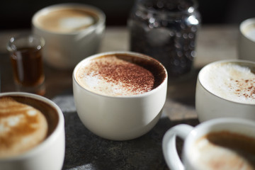 Hot coffee cup and coffee beans on wooden table..