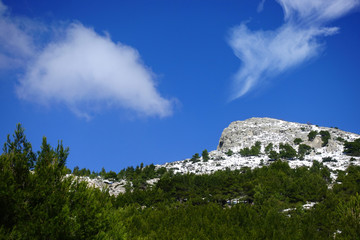 Winter photo of mount Parnitha covered with slight snow and deep blue cloudy sky on a sunny morning