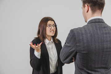 Two business partners have an expressive talk. Angry woman is shouting on the man, making crazy face expressions and motions.