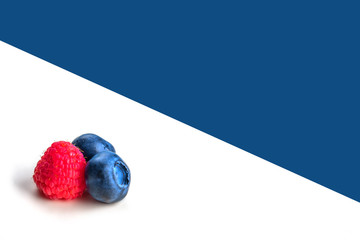 Blueberries and raspberry on whiteand blue background. Close up, top view, high resolution product. Harvest Concept