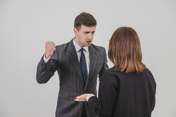 Boss and secretary having serious talk. Strict boss is threatening his young employee with a fist.