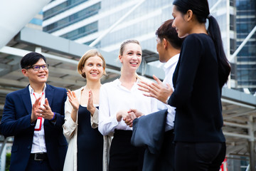 Business team celebrating and success concept.Two businessmen shaking hands with their colleagues applauding