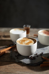 Hot coffee cup and coffee beans on wooden table..