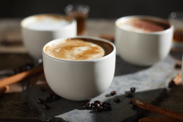 Hot coffee cup and coffee beans on wooden table..