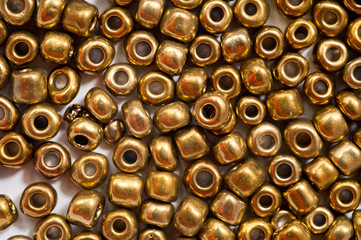 Round golden beads designed for making jewelry shot large on a white background