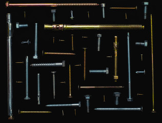 Knolling screws, various size and type of screws arranging at 90 degree angles from each other on black background