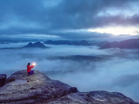 Girl sit on rock in  darkess holding in hands symbol of hope