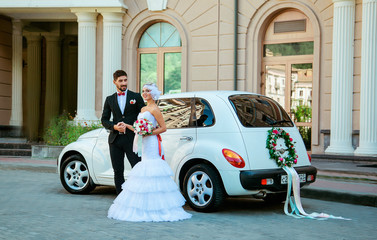 beautiful, loving couple on a wedding walk with a car