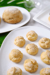choux cream or cream puff or French profiteroles with fresh cream set on cafe table.