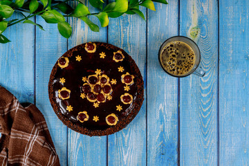 Chocolate cake with sour cherry on the top and cup of coffee.