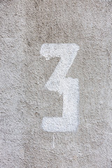 Number 3, three, street number sign on the wall