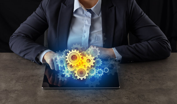 Business woman working on tablet with setting and gear concept