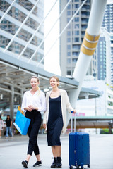 Travel and tourism concept. Two caucasian Woman traveler tourist walking with luggage map and shopping bag in the city