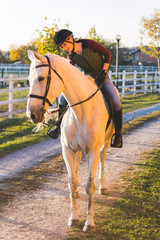 The owner and his white horse are preparing to ride.