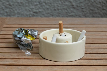 Ashtray bulging with cigarettes on wood table