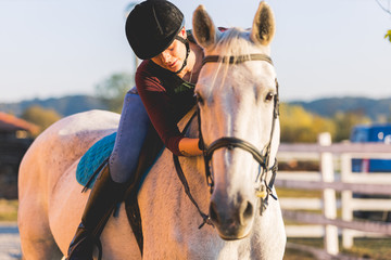 The owner and his white horse are preparing to ride.